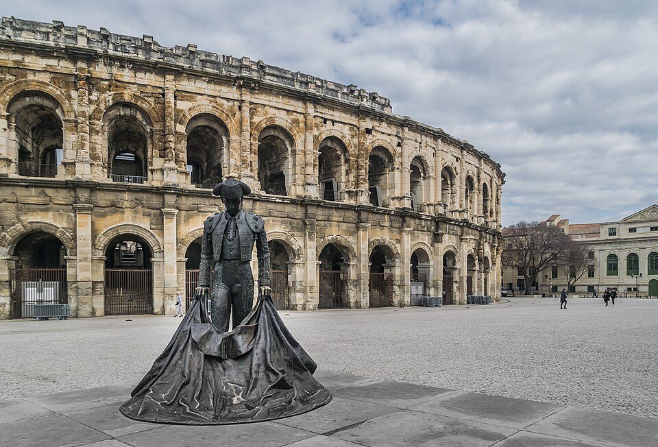 Les Arènes de Nîmes et la statue d'un torero sur le parvis