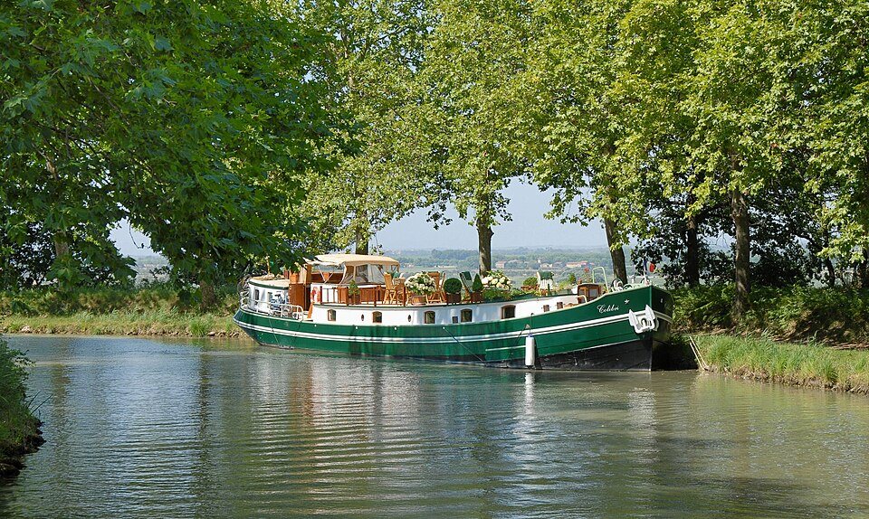 Ein Hausboot auf dem Canal du Midi unter den Platanen