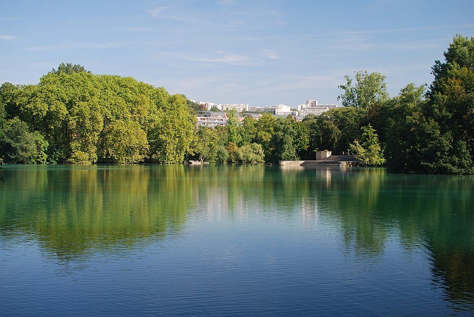 Le grand lac du Parc de la Tête d'Or bordé d'arbres, à Lyon